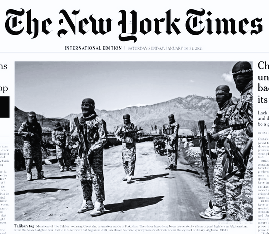 Armed men in camouflage uniforms and face coverings standing on a dirt road with mountains in background, wearing lace-up athletic sneakers.