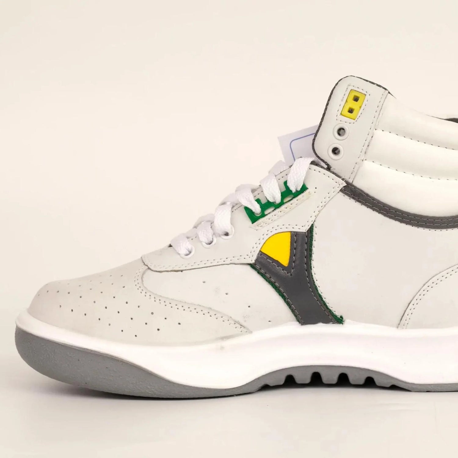 White and gray leather sneaker with yellow and green accents, perforated toe, and gray sole