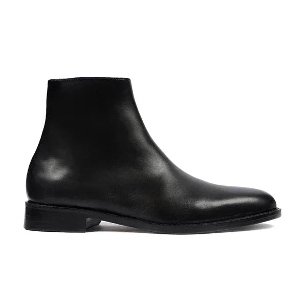 Black leather ankle boot with sleek design, low heel, and round toe on white background