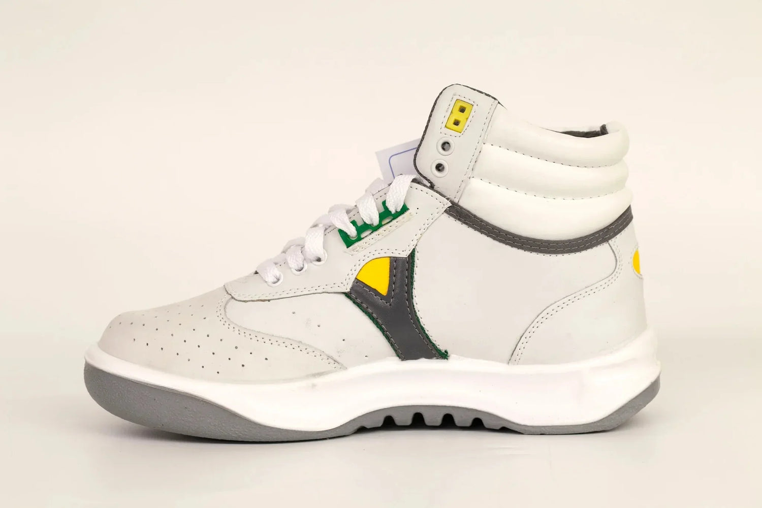 White high-top sneaker with gray, yellow, and green accents on a plain background